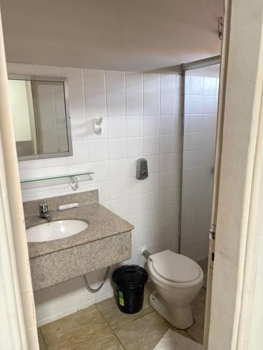 a bathroom with a sink and a toilet and a mirror at Quefren Residence Hotel in Uberaba