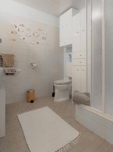 a white bathroom with a toilet and a shower at MOOKI Sky by Lake in Villach