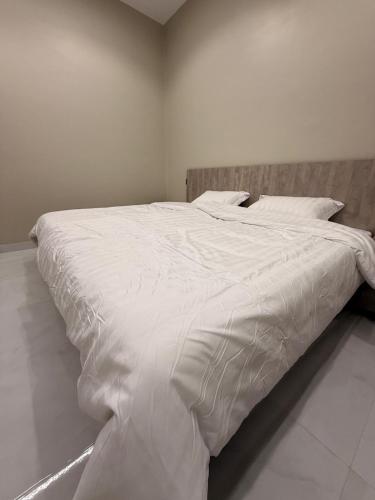 a large white bed in a white bedroom at Hail View شقق فيو حائل المخدومة in Hail