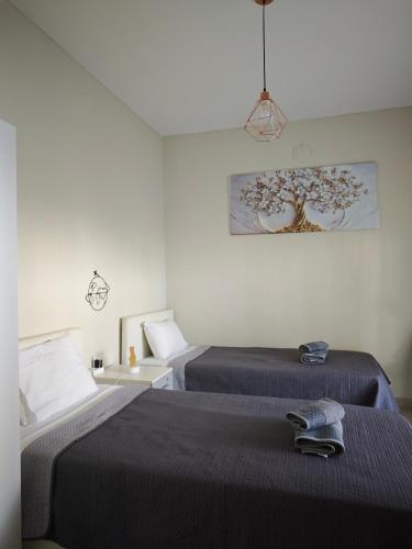 a bedroom with two beds and a painting on the wall at Elina House in Nikiti