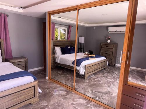 a bedroom with two beds and a mirror at Elegant 3-Bedroom Loft Condo in Kingston