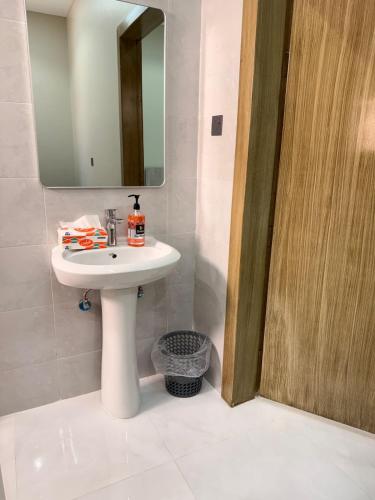 a bathroom with a white sink and a mirror at Hail View شقق فيو حائل المخدومة in Hail
