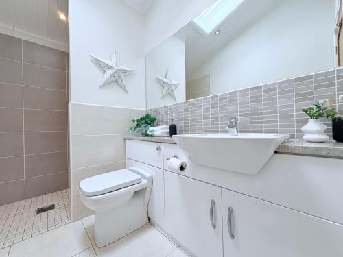 a white bathroom with a sink and a toilet at Sea View Retreat Lodge in Heysham