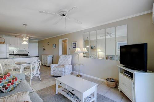 a living room with a couch and a tv and a kitchen at Beachwood Place 3E in Hilton Head Island