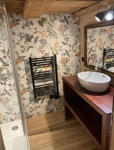 a bathroom with a sink and a mirror at Le vieux chalet in La Forclaz