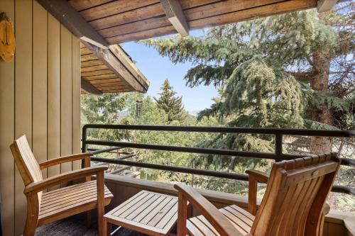 two chairs on a porch with a view of trees at Seasons Four #178 in Snowmass Village