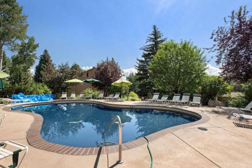 a large swimming pool with chairs and umbrellas at Seasons Four #178 in Snowmass Village