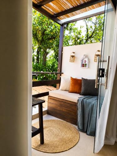 a screened in porch with a couch and a table at Morro de São Paulo - Boho Loft Escape Pool Balcony & Champagne in Cairu