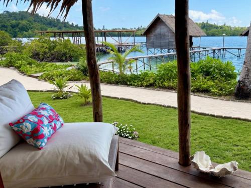 a couch on a porch with a view of the water at ipyum Premium Beach Guest House in Sageurin