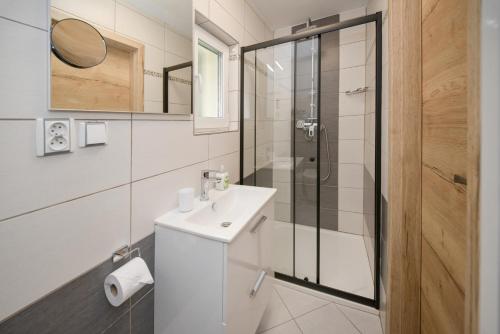 a white bathroom with a sink and a shower at Penzion Sv. Duch in Český Krumlov