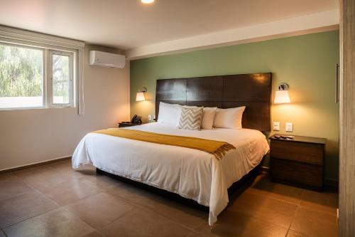 a bedroom with a large bed and a window at Hotel Omenia in Tequisquiapan