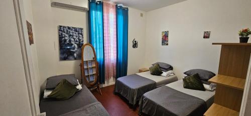 a small room with two beds and a mirror at AMCP Gîte - Montgiscard in Montgiscard
