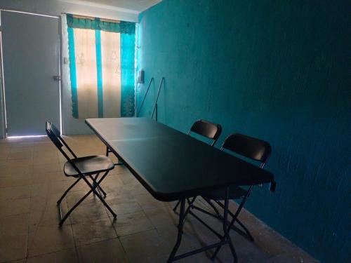 a table and chairs in a room with a blue wall at Casa naranjito in Cosoleacaque