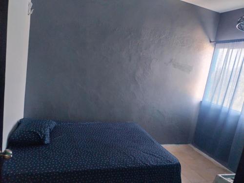a bedroom with a bed with a black wall at Casa naranjito in Cosoleacaque