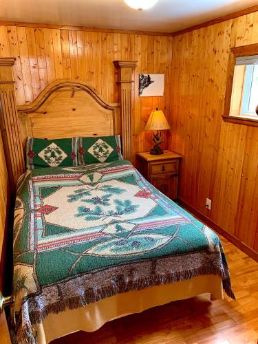 a bedroom with a bed in a room with wooden walls at Benzonia Rustic Resort in Benzonia