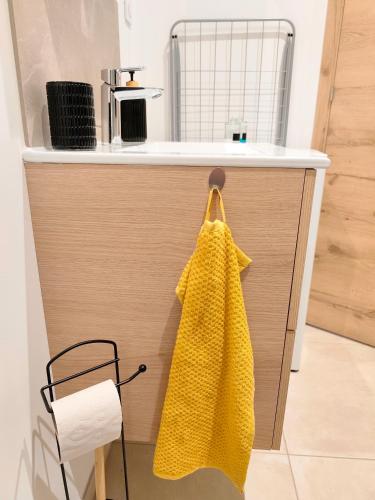 a kitchen counter with a yellow towel hanging from it at Studio Valentigney in Valentigney