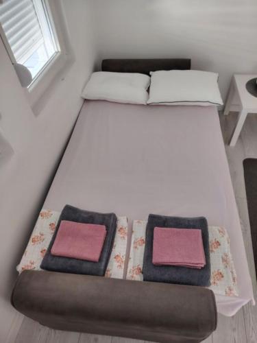 a bed with two pillows on it in a room at Tanja Apartment in Podgorica