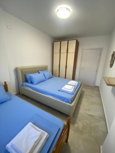a bedroom with two beds with blue sheets at Beachfront Apartment Durres in Durrës