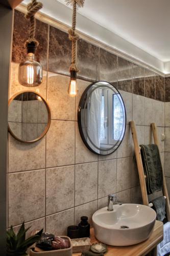 a bathroom with a sink and two mirrors at Casa Katrine in Lakíthra