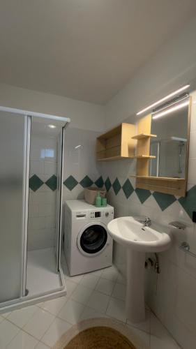 a bathroom with a washing machine and a sink at Riflesso Apartment in Blevio