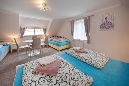 a bedroom with two beds and a table and a dining room at Penzion Sv. Duch in Český Krumlov