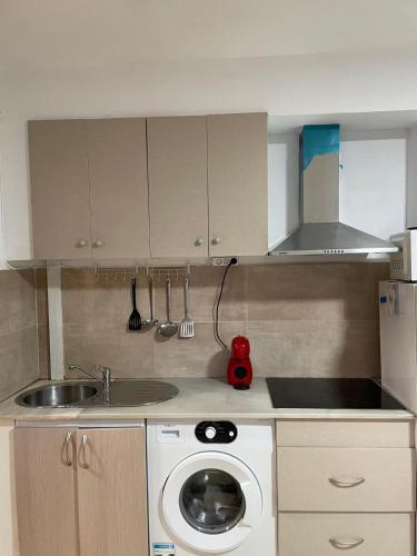 a kitchen with a washing machine and a sink at Atico Marin playa in Marín