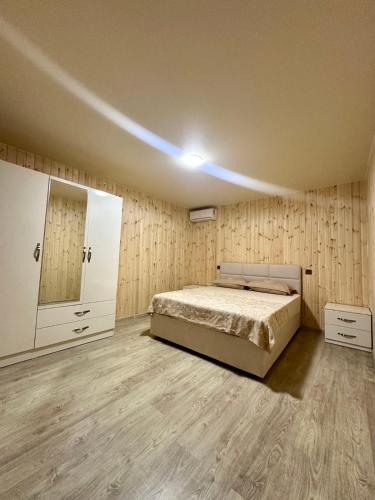 a bedroom with a bed in a room with wooden walls at Guest House Ucha in Stantsiya Chakva