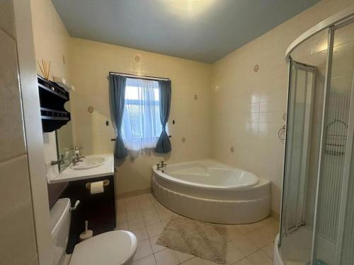 a bathroom with a tub and a toilet and a sink at Athenry Stay in Athenry
