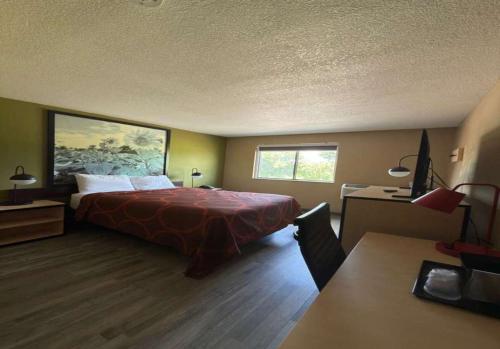 a hotel room with a bed and a desk at Super 8 by Wyndham Topeka/Wanamaker RD/I-70 in Topeka