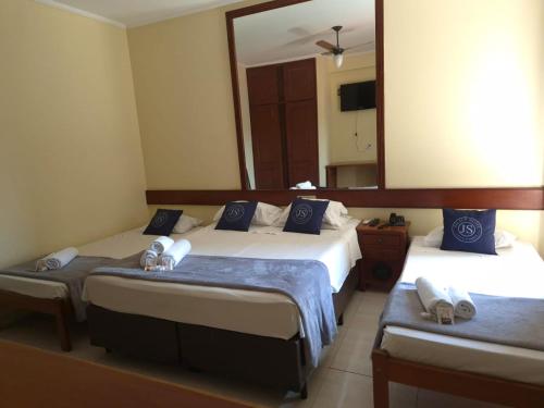 a bedroom with two beds and a large mirror at Palace Hotel Jacutinga JS in Jacutinga