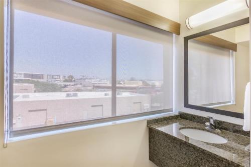 a bathroom with a large window and a sink at Best Western Plus Scottsdale Thunderbird Suites in Scottsdale