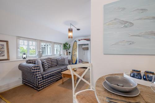 a living room with a couch and a surfboard on the wall at Beachday Kampen in Kampen