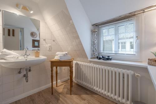 a bathroom with a sink and a mirror at Beachday Kampen in Kampen