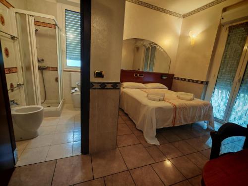 a bedroom with a bed and a bathroom with a tub at Motel Villaggio in Imola