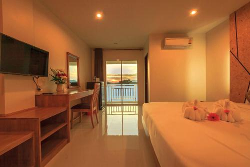 um quarto com uma cama, uma secretária e uma televisão em JS Residence Krabi em Cidade de Krabi