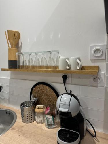 a kitchen counter with a toaster and glasses on a shelf at Les Perles de Limoux - Centre Clim Wifi Parking Gratuit in Limoux