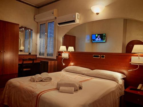 a hotel room with a bed with a tv on the wall at Motel Villaggio in Imola
