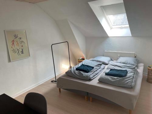 a bedroom with a bed with blue pillows on it at Stokbrogade 7 - lejlighed 2 in Hjørring