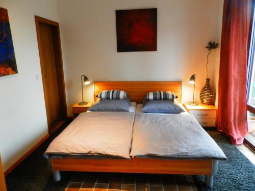 ein Schlafzimmer mit einem Bett mit zwei Kissen und zwei Lampen in der Unterkunft Saar-Mosel-Tal in Konz