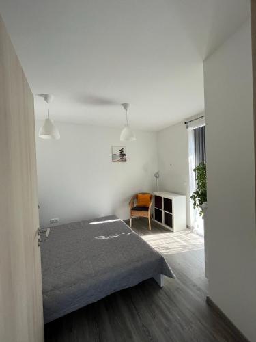 a bedroom with a bed and a chair in it at Sirály apartman in Keszthely