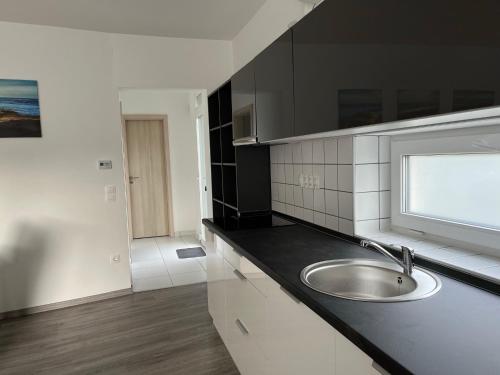 a kitchen with a sink and a window at Sirály apartman in Keszthely
