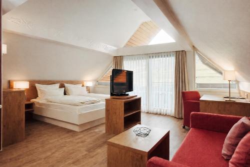 a hotel room with a bed and a tv at Hotel Garni Bergblick in Biberach bei Offenburg