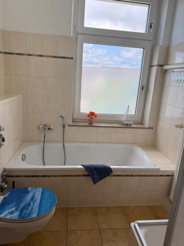 a bathroom with a bath tub and a window at Crampas 1 in Sassnitz
