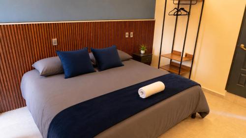 a bedroom with a large bed with blue pillows at Hotel Boutique Piedra & Altura in San Juan Teotihuacán