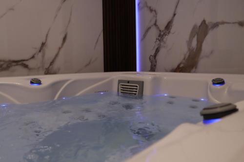a bathroom with a bath tub filled with water at Om relax apartman in Prijedor