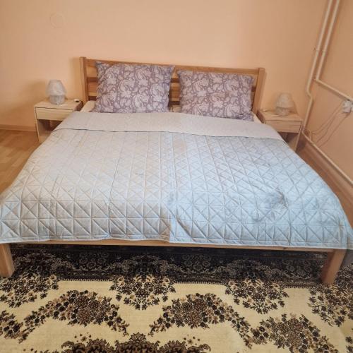 a bedroom with a bed with a blue comforter at Samu lakóház in Balatonberény