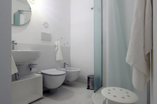 ein weißes Bad mit einem WC und einem Waschbecken in der Unterkunft Pasitea in Syrakus
