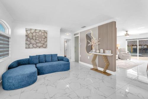 a living room with a blue couch and a table at 6BR Villa Tropical Haven Private Pool & BBQ in Homestead
