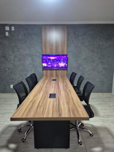 a conference room with a large wooden table and chairs at Palace Hotel Jacutinga JS in Jacutinga