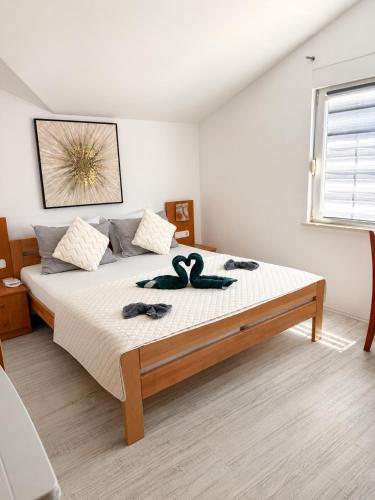 a bedroom with a large bed with two towels on it at Apartmani Villa Amfora - Free Parking in Neum